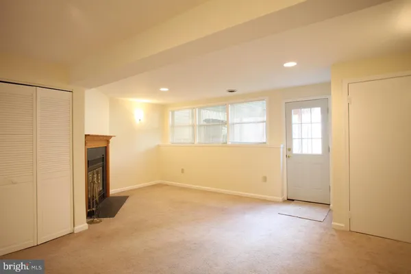 a view of an empty room with a fireplace and a window