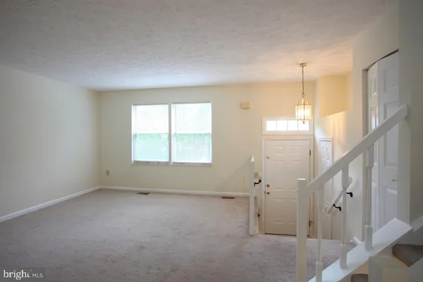 a view of a room with wooden floor and a window