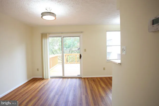 a view of a kitchen with wooden floor and a refrigerator