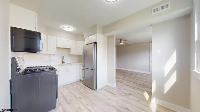 a kitchen with a refrigerator stove and wooden floor