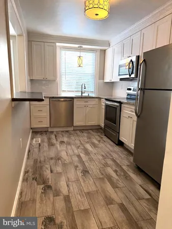 a kitchen with a refrigerator and a stove top oven