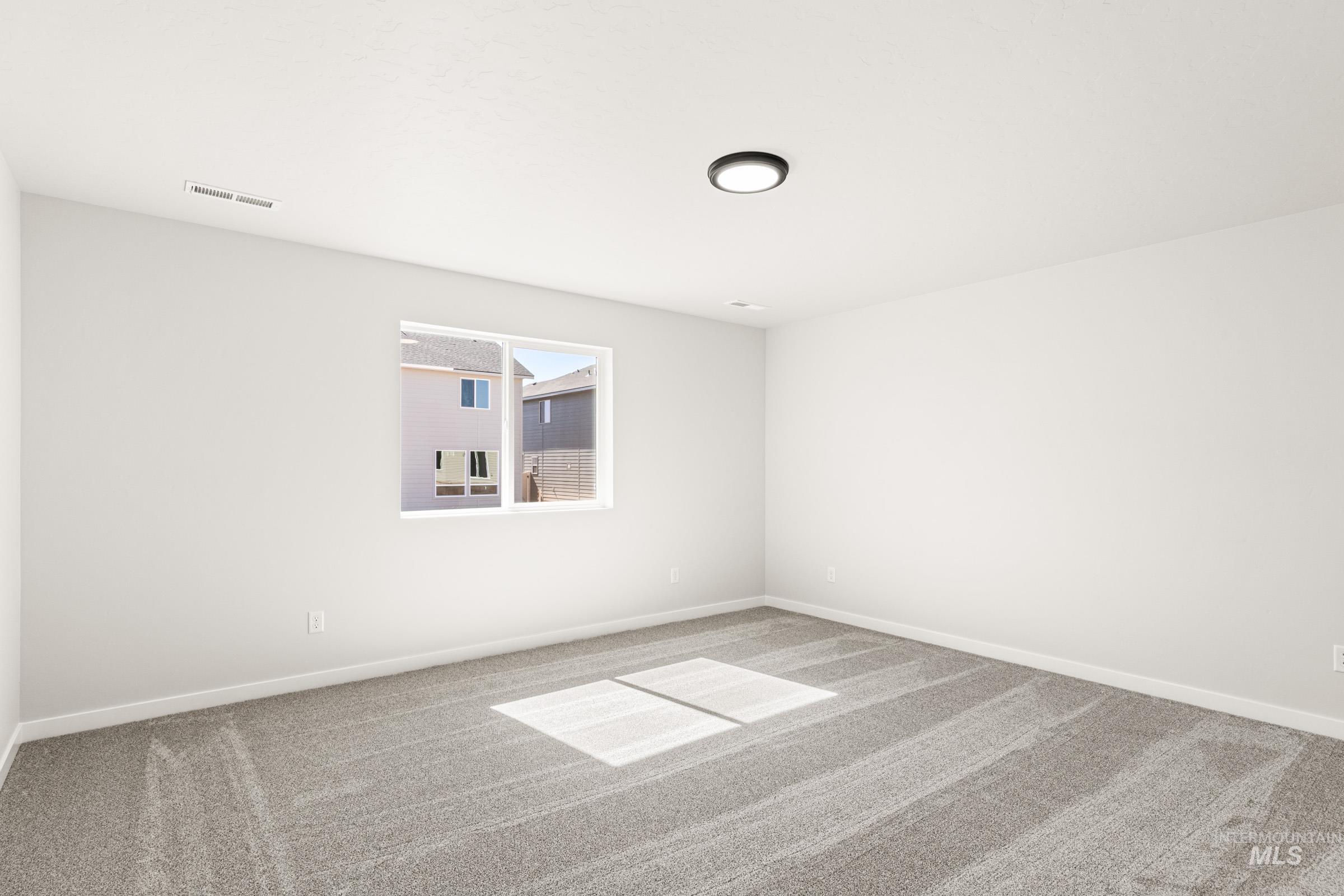 1077 West Jasper Street Meridian, ID 83642 - Photo 16 of 19 Spacious room featuring neutral carpeting, white painted walls, a single window, and a flush-mount ceiling light fixture