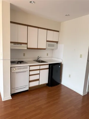a kitchen with a sink cabinets and a window
