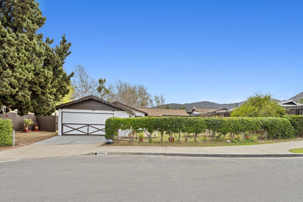 front view of a house with a yard and potted plants