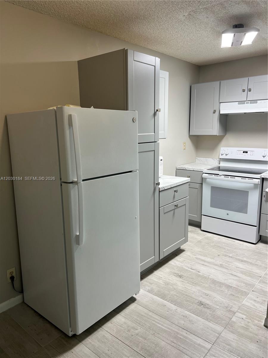 951 Lyons Road, Unit 6104 Coconut Creek, FL 33063 - Photo 10 of 18 a white refrigerator freezer and a stove in a kitchen