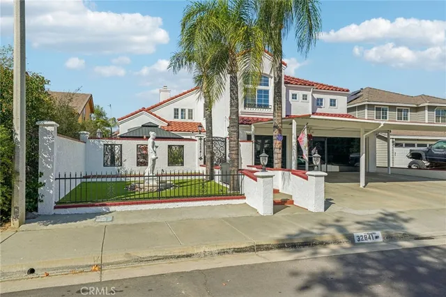 a front view of a house with a yard and potted plants
