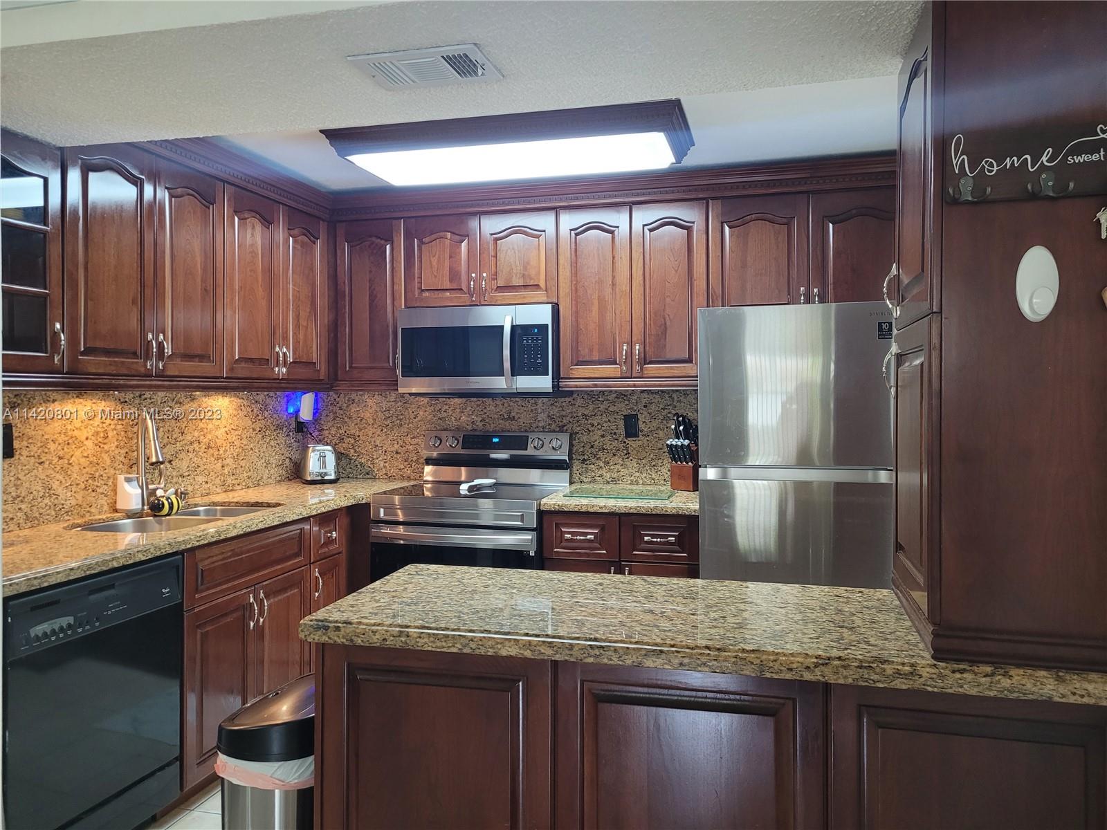 1066 North Hiatus Road, Unit 1066 Pembroke Pines, FL 33026 - Photo 1 of 33 a kitchen with kitchen island granite countertop a sink stove and refrigerator