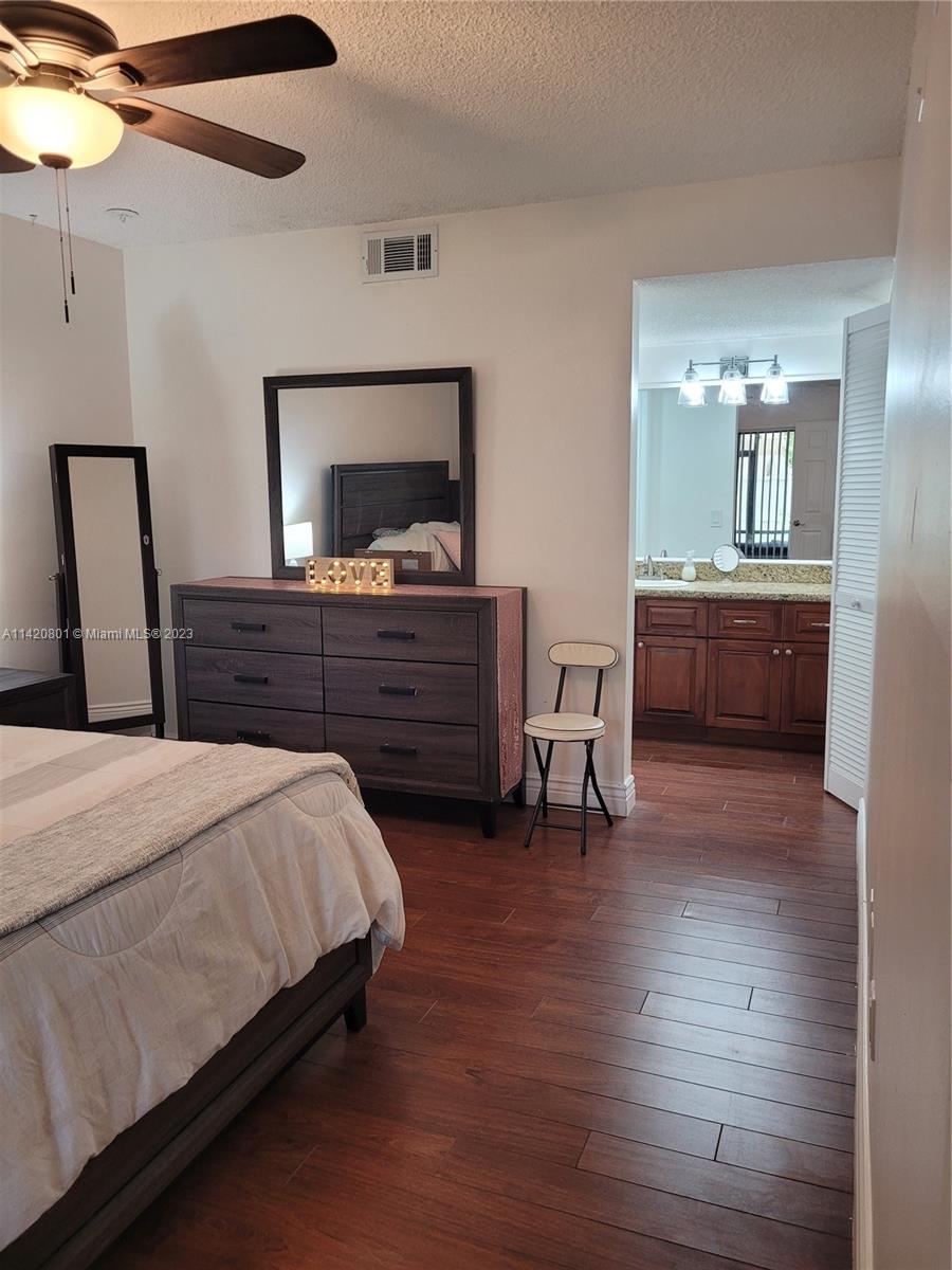 1066 North Hiatus Road, Unit 1066 Pembroke Pines, FL 33026 - Photo 13 of 33 a bed room with a bed and a mirror
