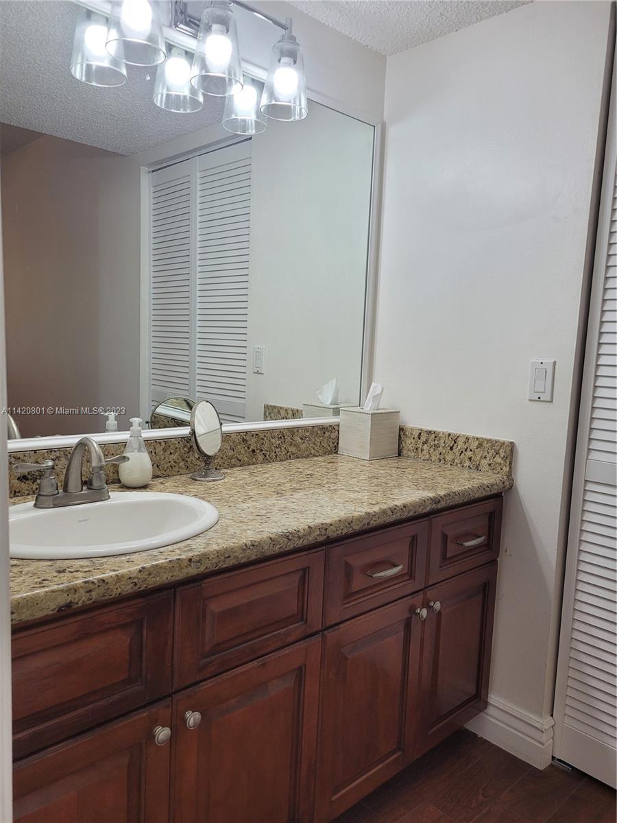 1066 North Hiatus Road, Unit 1066 Pembroke Pines, FL 33026 - Photo 14 of 33 a bathroom with a granite countertop sink a mirror and shower