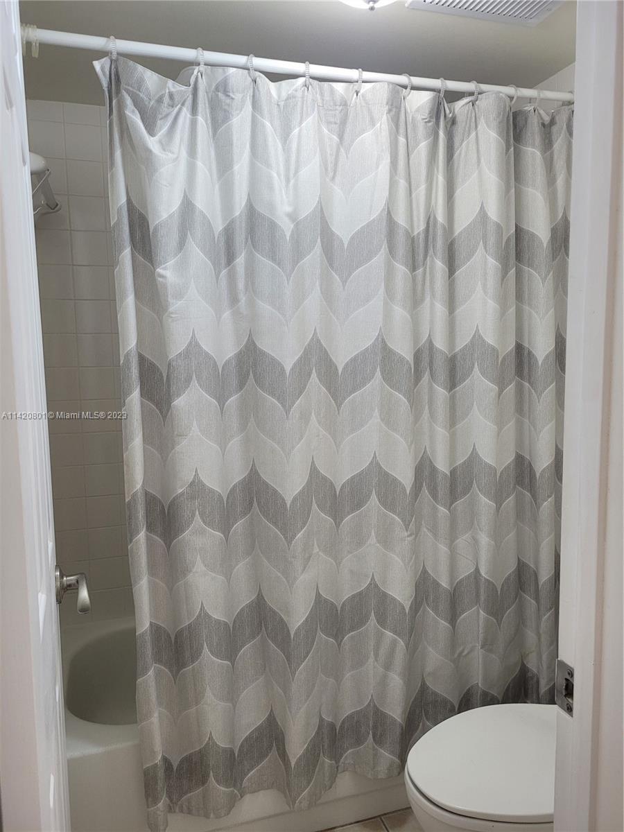 1066 North Hiatus Road, Unit 1066 Pembroke Pines, FL 33026 - Photo 15 of 33 a white toilet and shower curtain