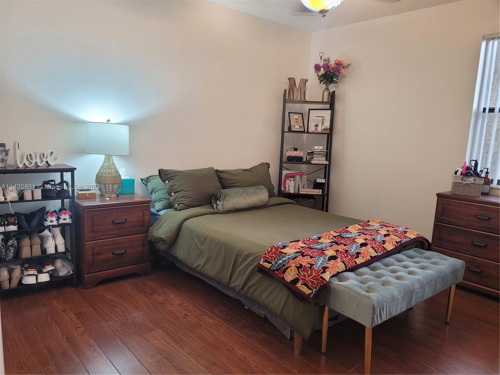1066 North Hiatus Road, Unit 1066 Pembroke Pines, FL 33026 - Photo 19 of 33 a bedroom with a bed and wooden floor