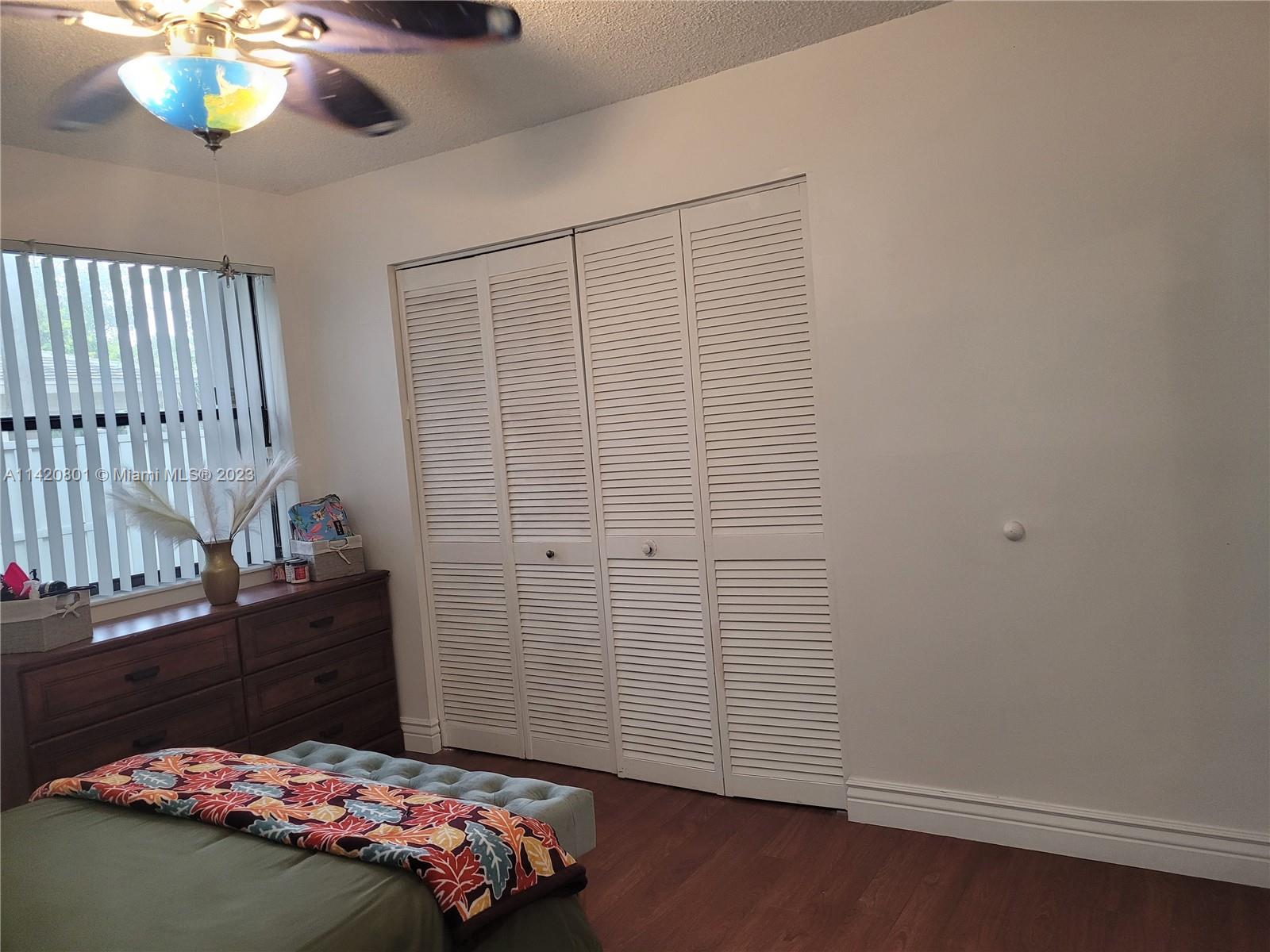 1066 North Hiatus Road, Unit 1066 Pembroke Pines, FL 33026 - Photo 20 of 33 a bedroom with a bed and a chandelier