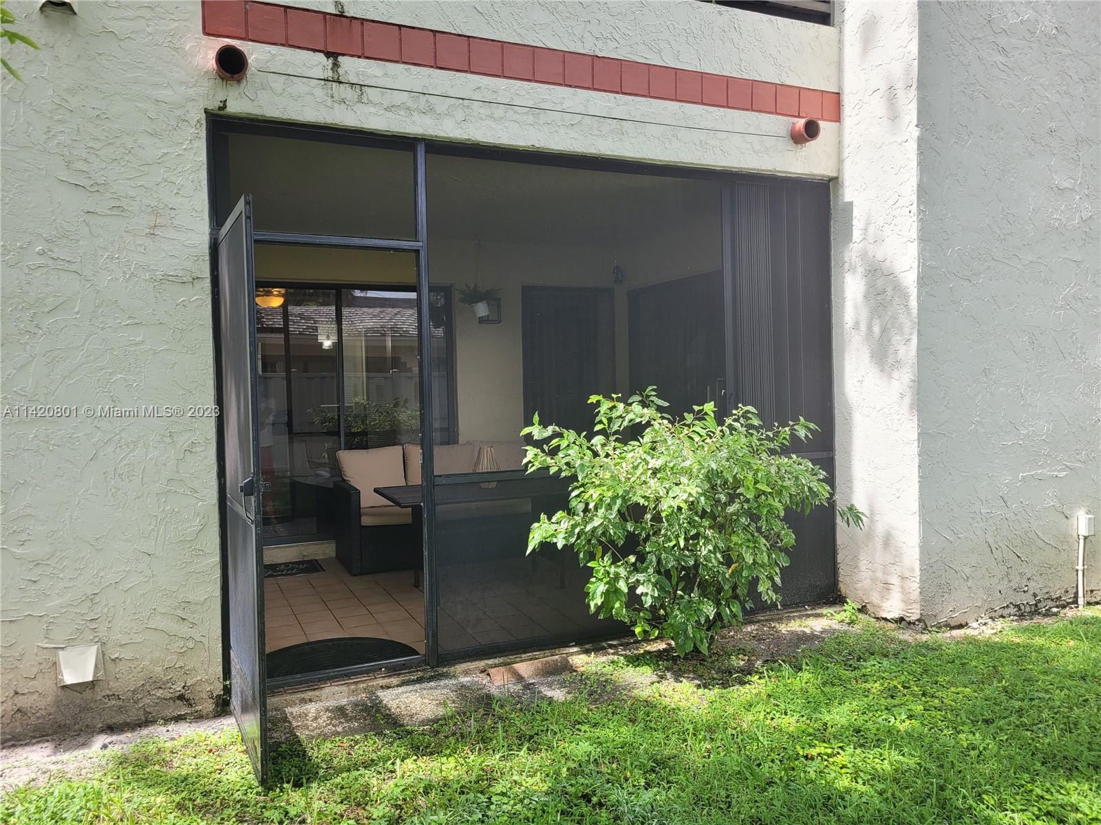 1066 North Hiatus Road, Unit 1066 Pembroke Pines, FL 33026 - Photo 26 of 33 a couple of potted plants in front of door