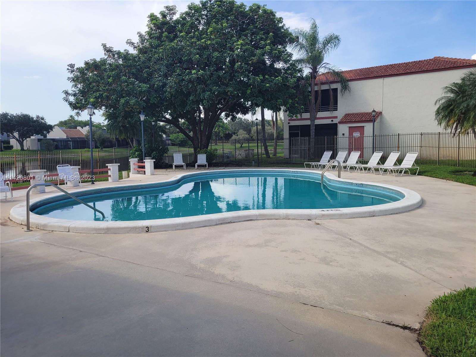 1066 North Hiatus Road, Unit 1066 Pembroke Pines, FL 33026 - Photo 29 of 33 a view of a house with pool and trees in the background
