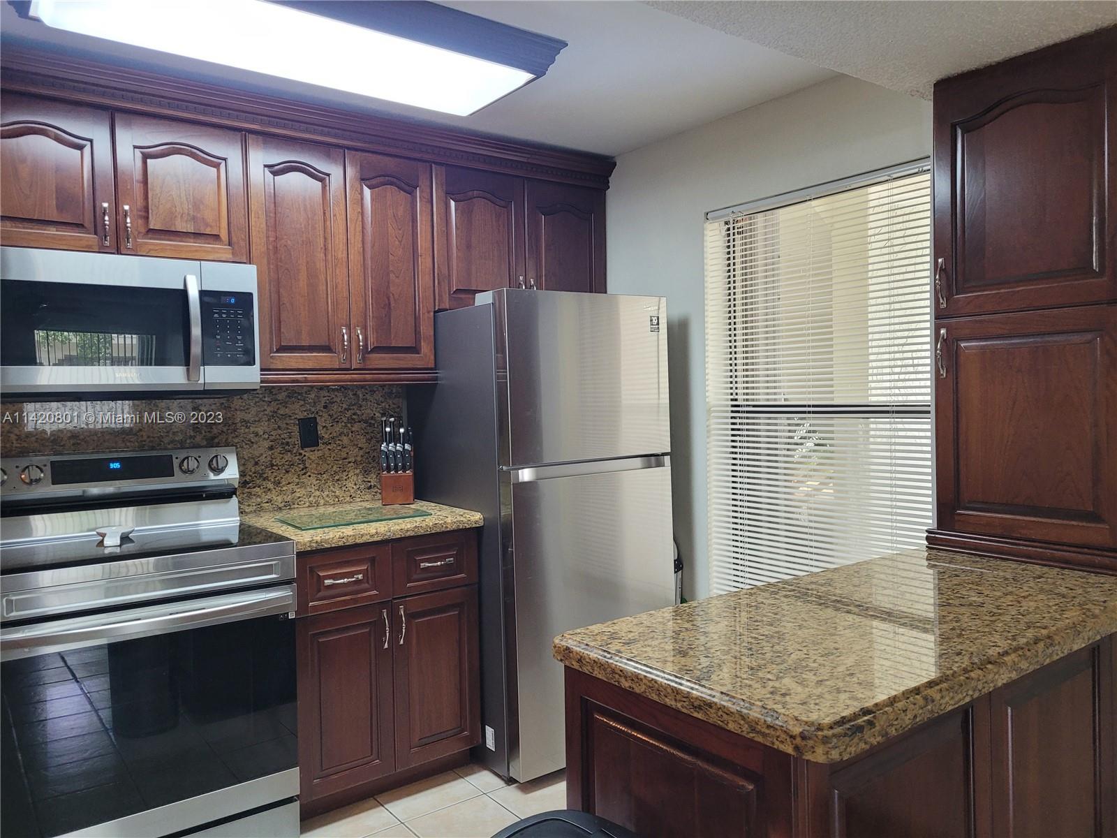 1066 North Hiatus Road, Unit 1066 Pembroke Pines, FL 33026 - Photo 7 of 33 a kitchen with stainless steel appliances granite countertop a refrigerator oven a stove and a sink