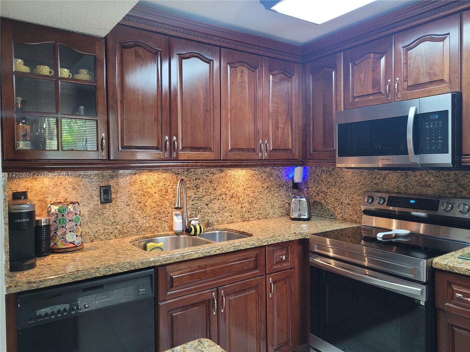 1066 North Hiatus Road, Unit 1066 Pembroke Pines, FL 33026 - Photo 8 of 33 a kitchen with granite countertop cabinets stainless steel appliances and a sink