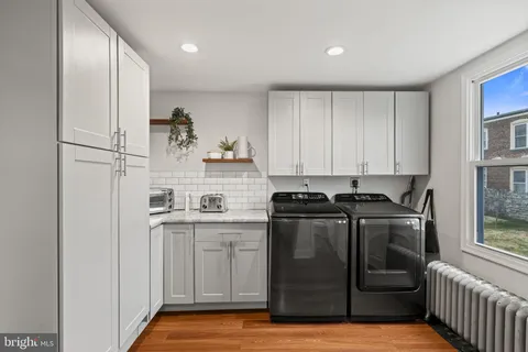 a kitchen with stainless steel appliances granite countertop a refrigerator a sink and white cabinets