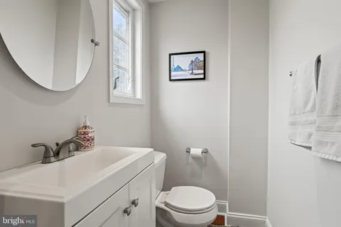 a bathroom with a toilet a sink and mirror