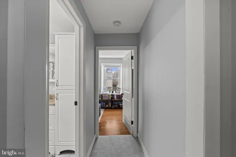 a view of a hallway with bathroom and wooden floor