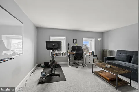 a living room with furniture a rug and a flat screen tv