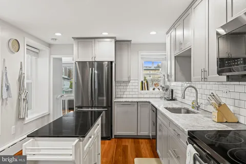 a kitchen with granite countertop a refrigerator stove and sink