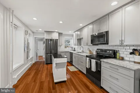 a kitchen with stainless steel appliances a refrigerator sink and microwave