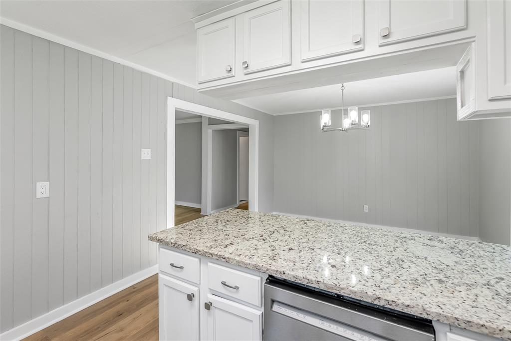 224 Prysock Road Doyline, LA 71023 - Photo 15 of 38 Kitchen featuring white cabinetry, wood finished floors, light stone counters, stainless steel dishwasher, and hanging lights