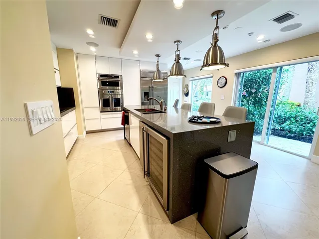a kitchen with stainless steel appliances granite countertop a sink a stove and a refrigerator