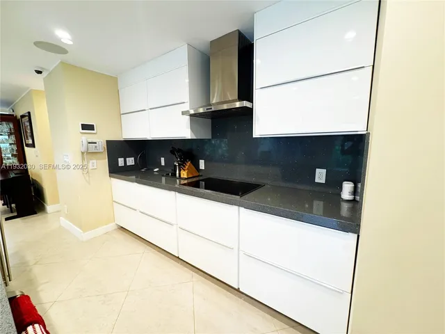 a kitchen with granite countertop a sink a stove and a refrigerator