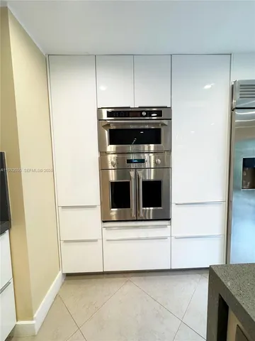 a view of kitchen with stainless steel appliances wooden cabinet and a refrigerator