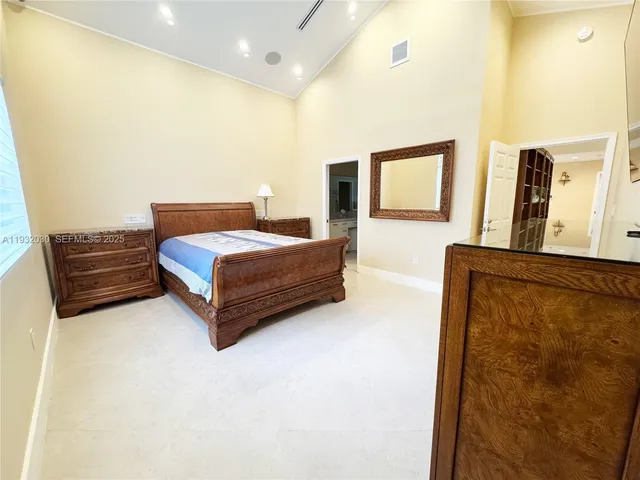 a spacious bedroom with a bed and dresser