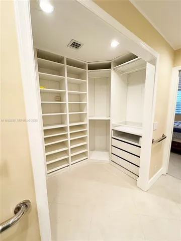 a view of walk in closet with empty racks