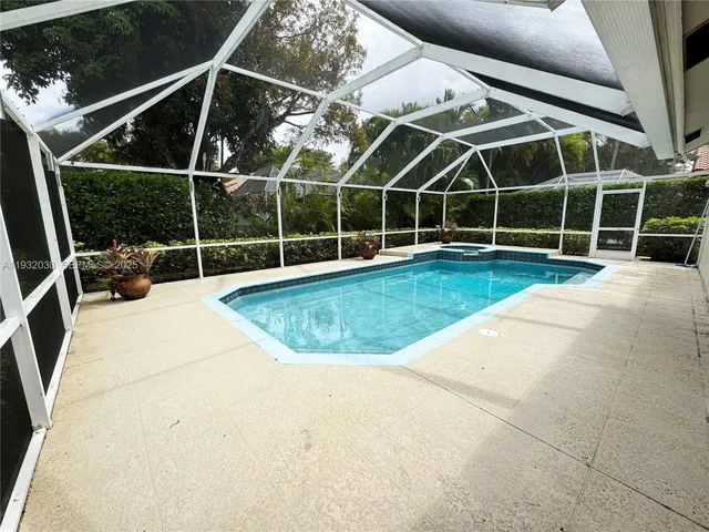 a front view of a house with a yard and potted plants