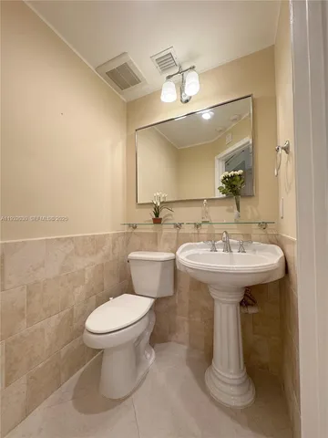 a bathroom with a sink toilet and mirror