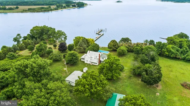 an aerial view of a house with a yard and lake view