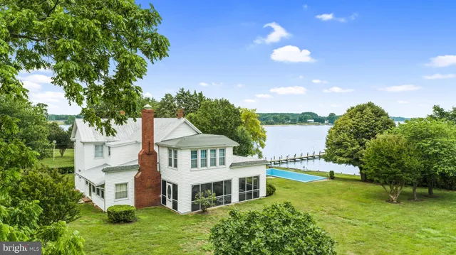 an aerial view of a house with swimming pool and big yard