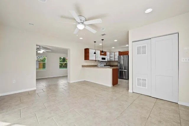 a view of a kitchen with a sink and dishwasher a refrigerator with white cabinets