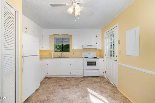 a view of a kitchen with white cabinets