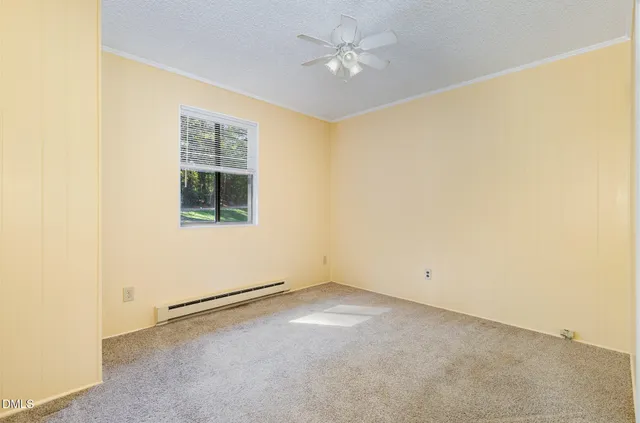 an empty room with a window and a ceiling fan