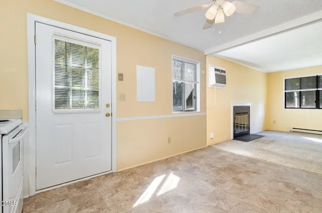 an empty room with windows cabinet and mirror
