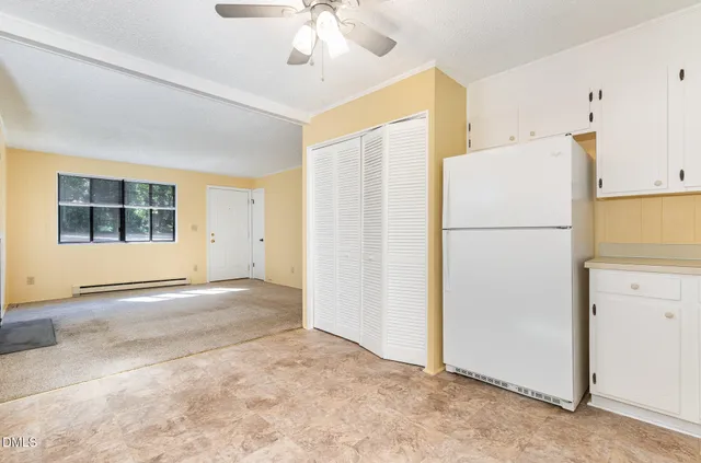 a view of a kitchen with a refrigerator cabinet and a refrigerator
