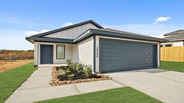 a front view of house with yard and garage