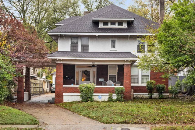 a view of a white house with large windows and a yard