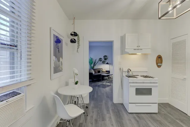 a kitchen with a stove cabinets and wooden floor