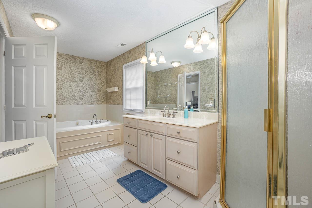 2009 Ryerson Drive Garner, NC 27529 - Photo 22 of 27 a bathroom with a bathtub a sink and a mirror