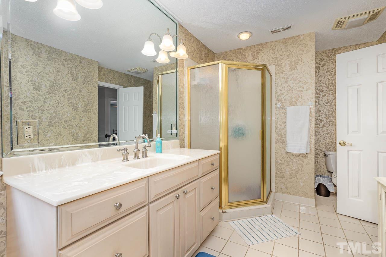 2009 Ryerson Drive Garner, NC 27529 - Photo 23 of 27 a spacious bathroom with a shower sink and mirror