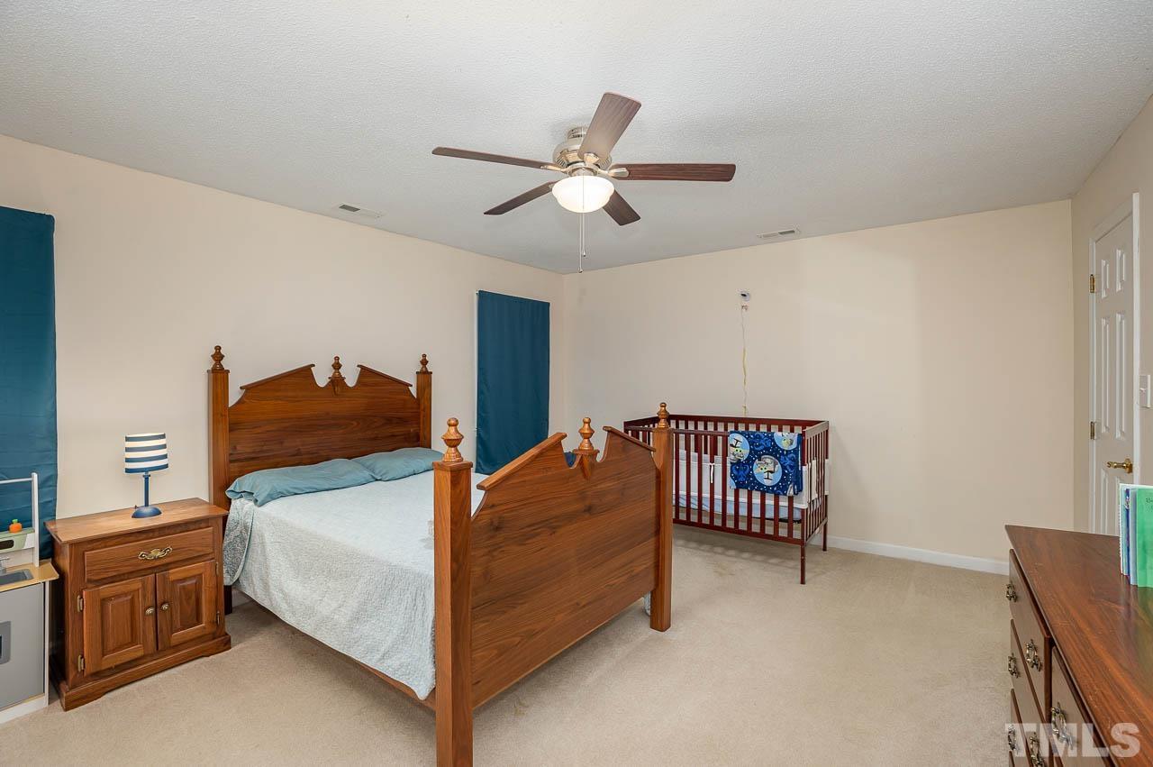 2009 Ryerson Drive Garner, NC 27529 - Photo 25 of 27 a bedroom with a bed and a chandelier