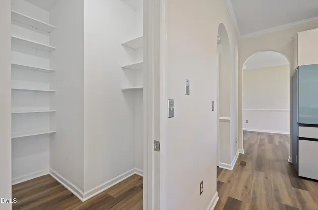 a view of a hallway with wooden floor and closet