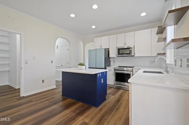 a large kitchen with stainless steel appliances granite countertop a stove a sink and a refrigerator