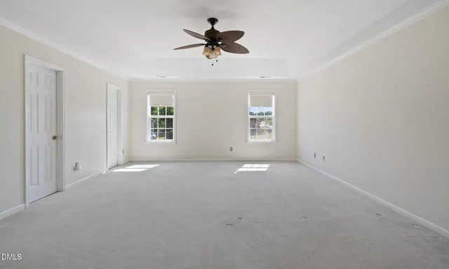 an empty room with a ceiling fan and window